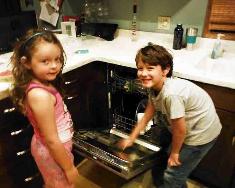 Kids conducting experiment in the effectiveness of automatic dishwasher in sanitizing dishes